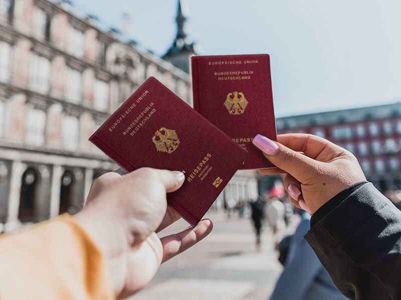 Personen zeigen deutschen Pass nach Einbürgerung
