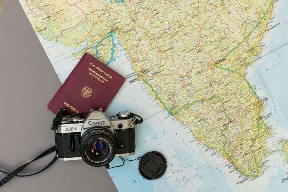 Auf diesem Bild sieht man einen deutschen Pass und eine Videokamera. Sie liegen auf einer Landkarte
