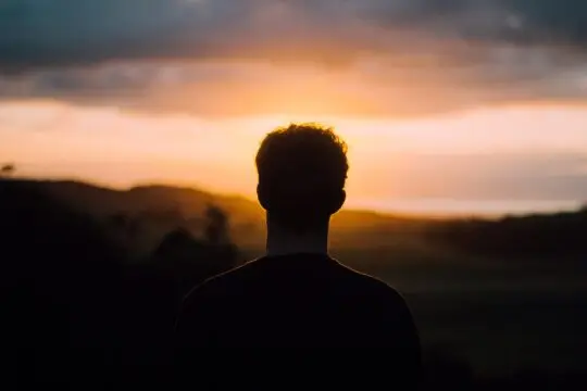 Auf diesem Bild guckt ein Mann zum Sonnenaufgang. Es gibt 5 sichere Wege von der Duldung ins Aufenthaltsrecht.