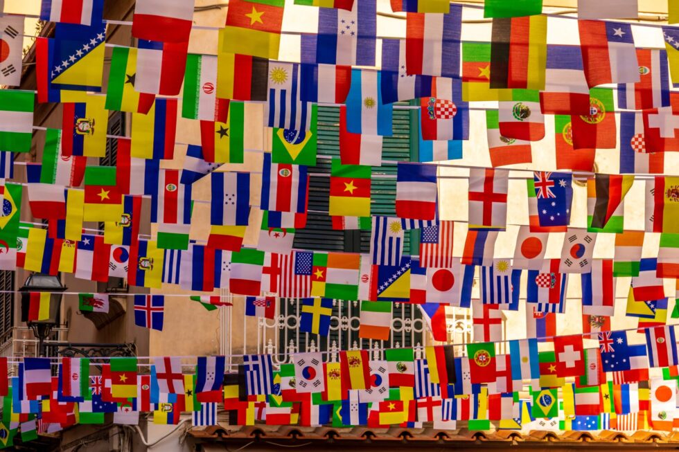 In this picture you can see many flags hanging in a shopping street