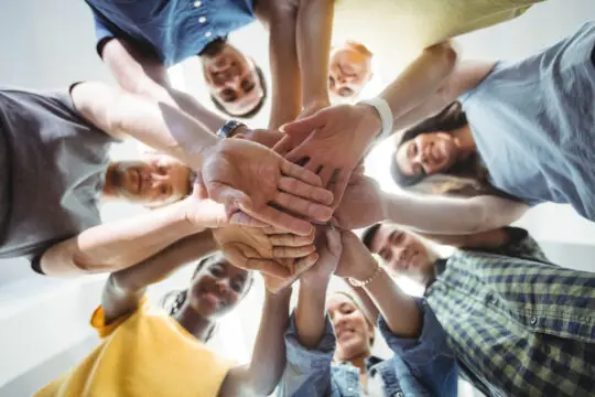 Auf diesem Bild sieht man junge Menschen die sich an der Hand halten. Als Azubi die Einbürgerung zu erhalten ist unter Umständen möglich