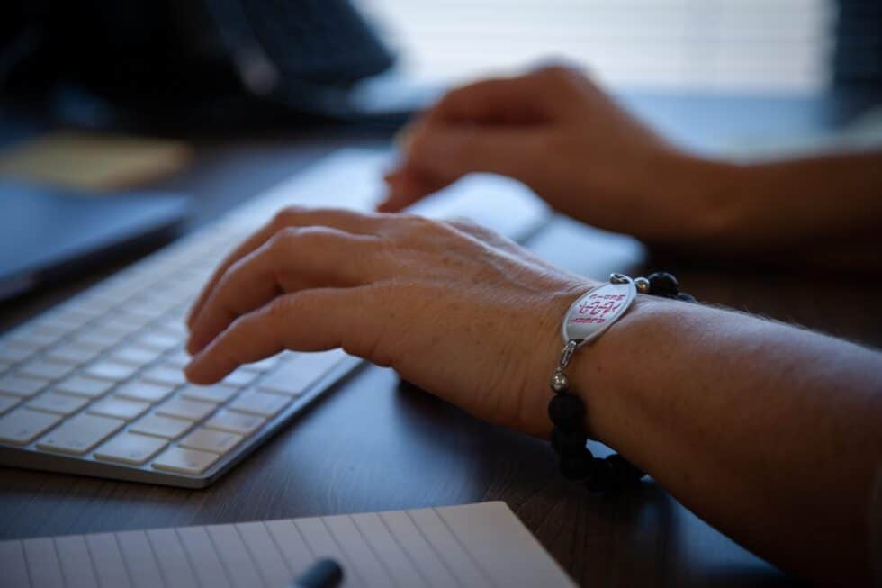 In this photo, a person is typing a word into a computer.