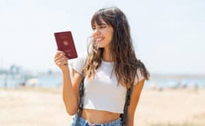 Auf diesem Foto sehen Sie eine junge Frau glücklich mit einem deutschem Reisepass. Mit dem neuen Einbürgerungsgesetz soll die Einbürgerung nach 3 Jahren möglich sein.