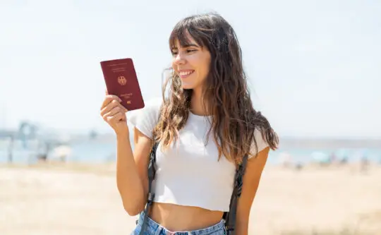 Auf diesem Foto sehen Sie eine junge Frau glücklich mit einem deutschem Reisepass. Mit dem neuen Einbürgerungsgesetz soll die Einbürgerung nach 3 Jahren möglich sein.