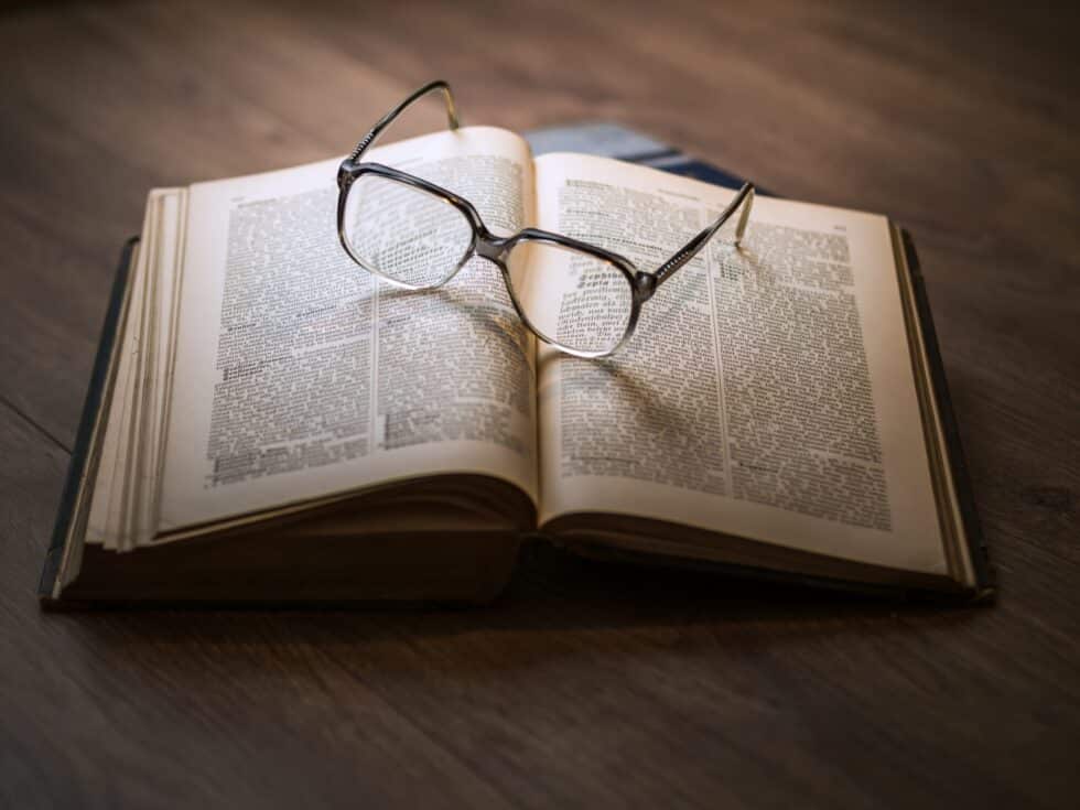 Nesta imagem, vêem-se óculos de leitura num livro de direito