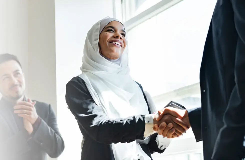 Auf diesem Foto sehen Sie eine muslimische Frau beim Händeschütteln.