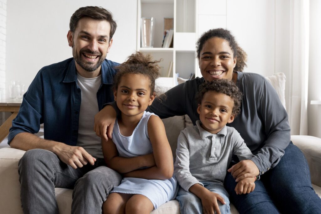 Auf diesem Foto ist eine Familie zu sehen. Sie verbringt Zeit auf dem Sofa