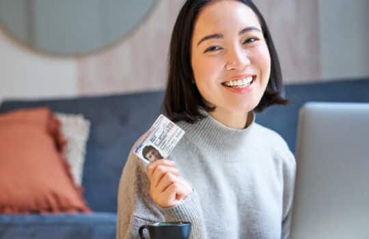 In this photo you can see a happy, smiling girl with a card for Residence permit Paragraf 21 AufenthG