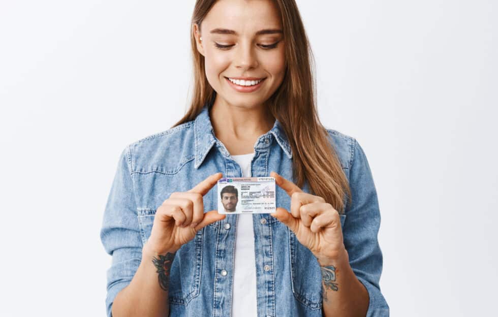 在这张照片中，您可以看到一位面带微笑的女士。她手里拿着一张印有 Paragraf 25 Abs 5 AufenthG 居住许可证的卡片。