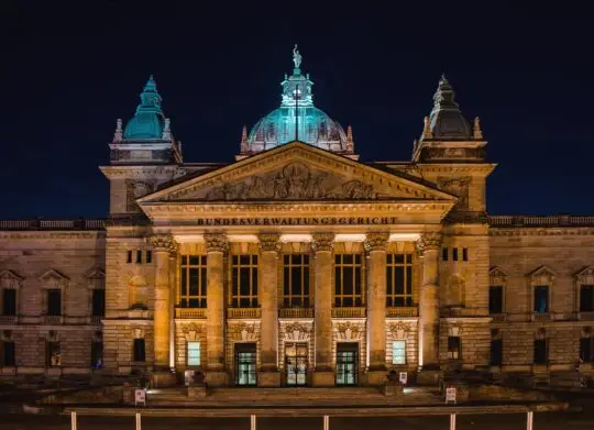 Nächtliche Ansicht des Bundesverwaltungsgerichts in Leipzig, beleuchtet und majestätisch. Dieses Gericht könnte im Rahmen einer Untätigkeitsklage bezüglich der Einbürgerung eine Rolle spielen.