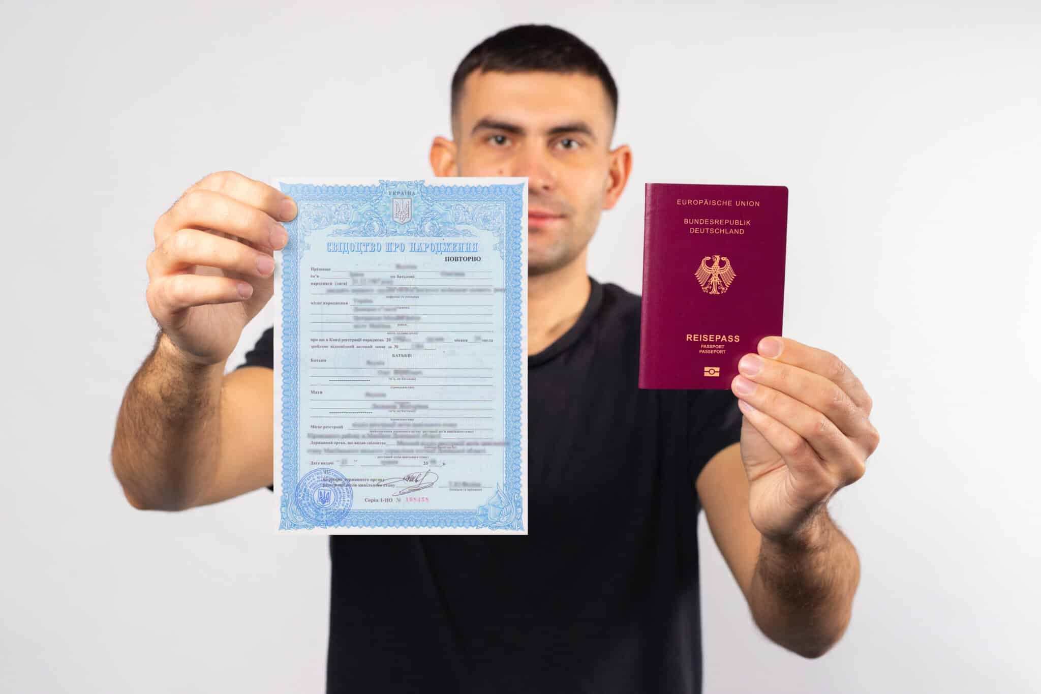 Ein Mann hält eine ukrainische Heiratsurkunde und deutschen Reisepass in den Händen, symbolisiert Einbürgerung ohne Geburtsurkunde.