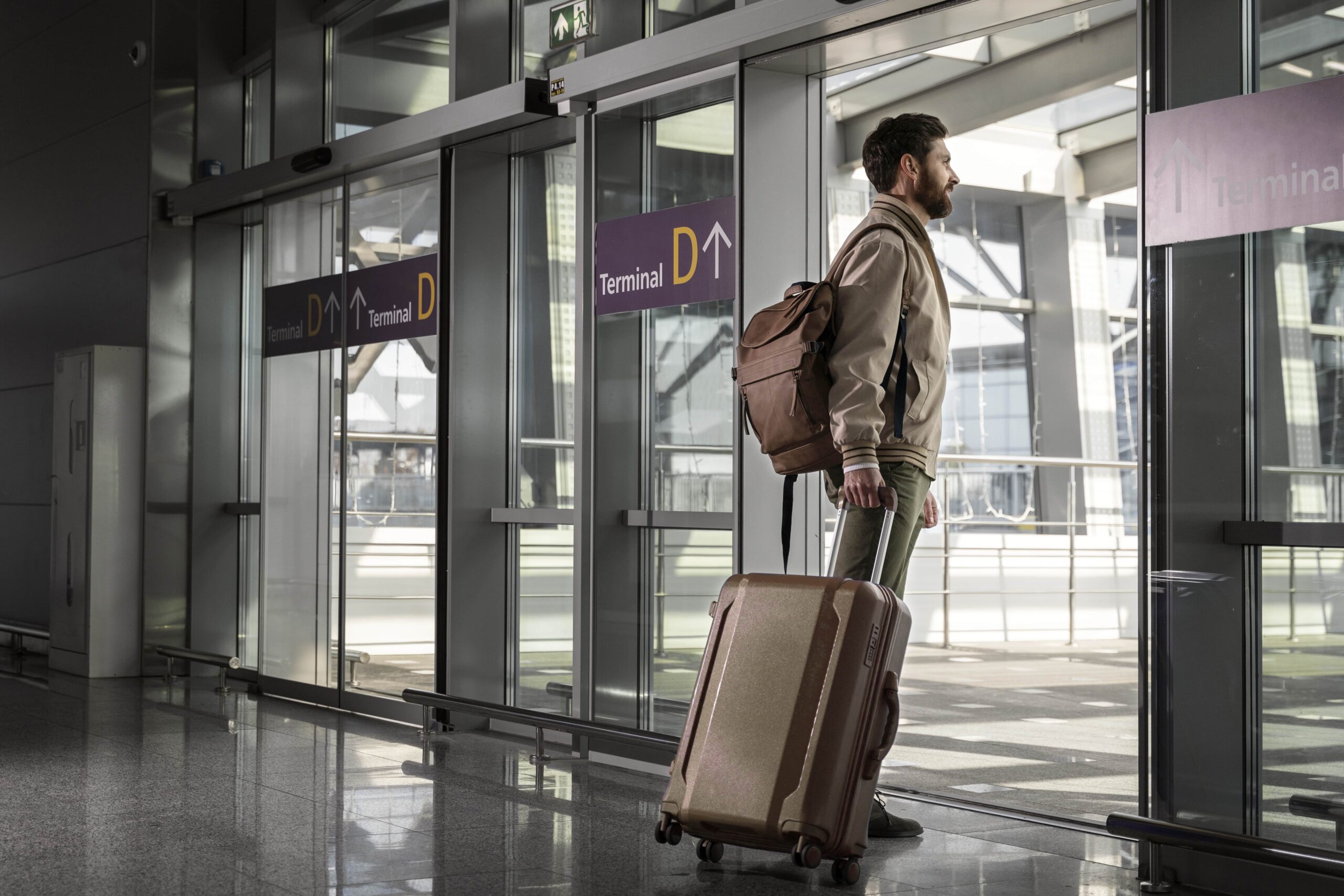 Mann mit Koffer und Rucksack am Flughafen, der nach Deutschland einreist – passend zum Aufenthaltstitel nach § 38a AufenthG.