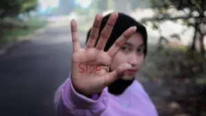 Woman shows palm with the word &#039;STOPP&#039; written on it, symbolizing the discourse on the possible stop of asylum applications for Syrians