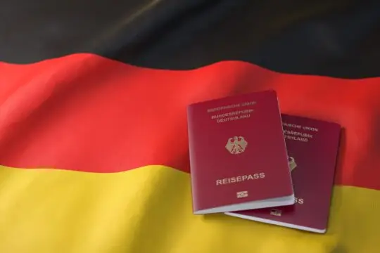 Zwei deutsche Pässe auf einer deutschen Flagge als Symbol zum Thema Deutscher Pass Voraussetzung