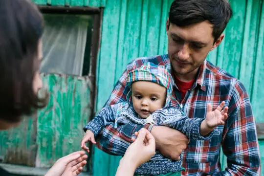 Das Bild zeigt einen Vater mit Migrationshintergrund, der sein kleines Kind im Arm hält. Familiennachzug, Turbo-Einbürgerung: Über diese fünf Reformen hat der Bundesrat nun entschieden. Was bedeutet das für Migranten und Migrantinnen.