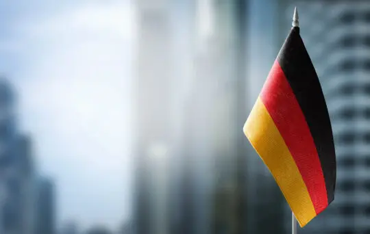 Das Bild zeigt die deutsche Flagge in den Farben Schwarz, Rot, Gold. Die Turbo-Einbürgerung in Deutschland steht kurz vor dem Aus. Aber wie sieht es in anderen Ländern aus? Welche Fristen für die Einbürgerung gelten?