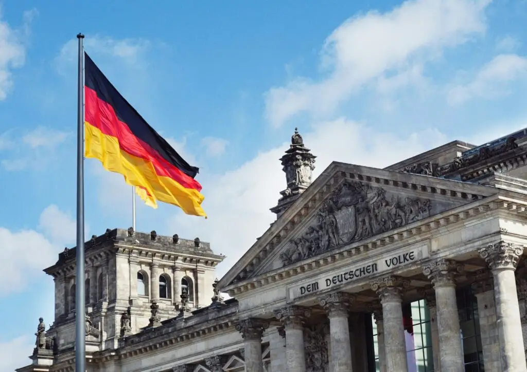 Das Bild zeigt die deutsche Flagge vor dem Bundestag in Berlin. Die Turbo-Einbürgerung steht vor dem Aus. Schon in den kommenden Wochen könnte die Bundesregierung über das neue Gesetz entscheiden und die Einbürgerung nach drei Jahren abschaffen. Alle wichtigen Fakten im Überblick.
