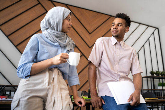 Das Bild zeigt zwei Fachkräfte mit Migrationshintergrund. Eine aktuelle Studie zeigt: Migrant:innen arbeiten besonders häufig in Berufen, in denen Fachkräftemangel herrscht.