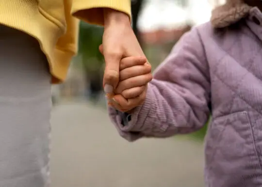 Das Bild zeigt die Hand einer erwachsenen Person, die die Hand eines Kindes hält. Es steht symbolhaft für den Familiennachzug bei subsidiärem Schutz. Neue Zahlen zeigen, dass seit der Aussetzung des Familiennachzugs Visa trotz Härtefall nur sehr selten erteilt werden.